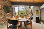 The dining and living area is separated by the stone fireplace